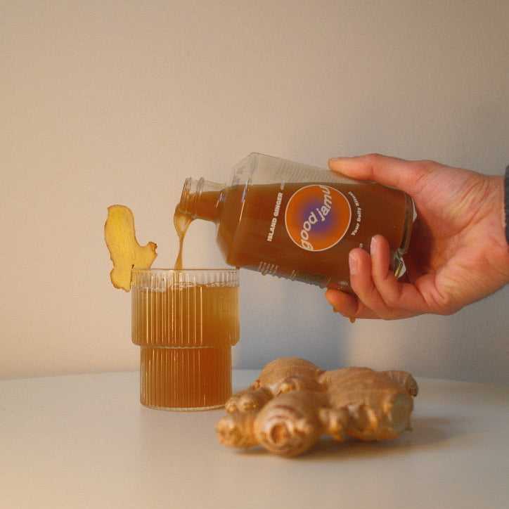 Island Ginger gember drank wordt in glas geschonken met verse gember ernaast, perfecte biologische jamu voor energie en detox.