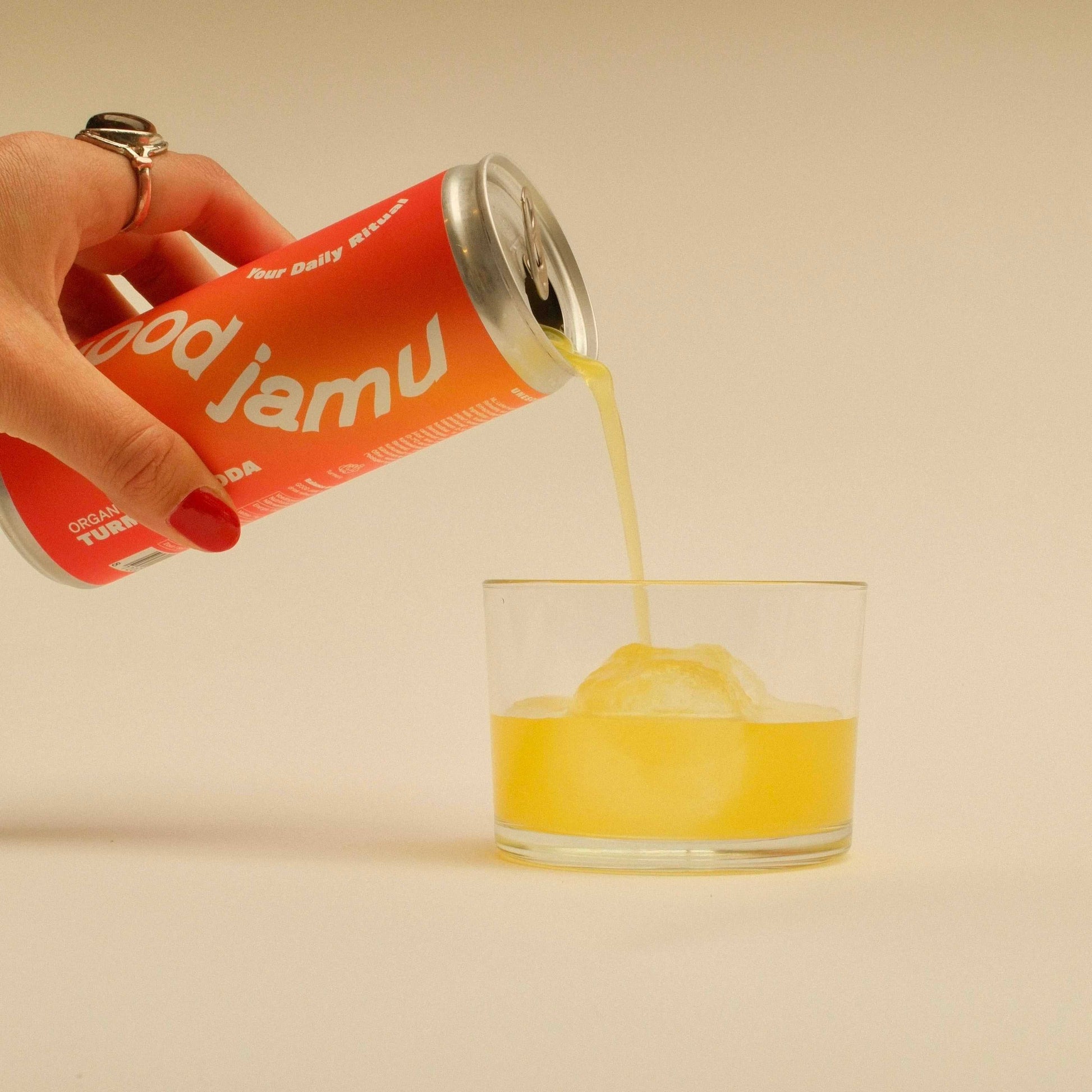 Good Jamu biologische kurkuma frisdrank wordt in een glas geschonken, perfect voor een verfrissende en gezonde dorstlesser.