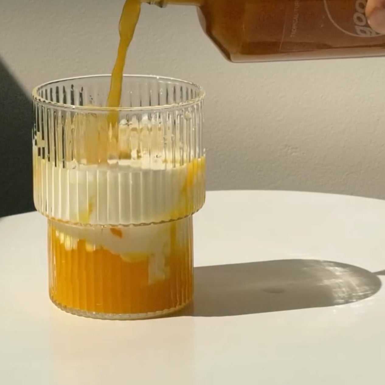 Tropical Turmeric elixer wordt in een glas met melk geschonken, ideaal als functionele kruidendrank met kurkuma en gember voor natuurlijke energie.